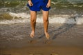 Legs of woman in blue dress jumping on the shore of the beach Royalty Free Stock Photo