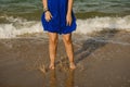 Legs of woman in blue dress jumping on the shore of the beach Royalty Free Stock Photo