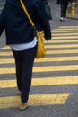 Legs of woman crossing the street on yellow zebra Royalty Free Stock Photo