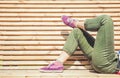 Legs of woman in green pants and purple sneaker lying on the ben