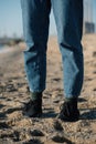 Legs of woman in jeans on sand at a beach. Walking in comfortable shoes on beach. Royalty Free Stock Photo