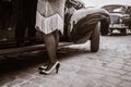 Legs of woman near old auto. Young woman in high heels shoes Royalty Free Stock Photo