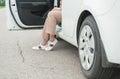 Legs of woman with sneakers out of white car on the road Royalty Free Stock Photo