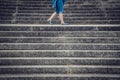 Legs of a woman walking between concrete stairs Royalty Free Stock Photo