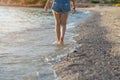 Legs of women walking on the beach at sunset. Royalty Free Stock Photo