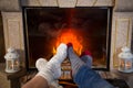 Legs in woolen socks heat up near fireplace Royalty Free Stock Photo