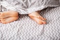 Legs of a young couple lie on a blanket in bed Royalty Free Stock Photo