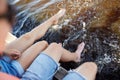 Legs of young couple sitting on river berth