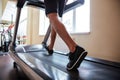 Legs of young fitness man running on treadmill in gym Royalty Free Stock Photo