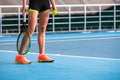 Legs of young girl in a closed tennis court with ball and racket Royalty Free Stock Photo