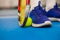 Legs of young girl in a closed tennis court with ball and racket Royalty Free Stock Photo