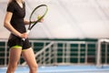 Legs of young girl in a closed tennis court with ball and racket Royalty Free Stock Photo