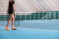 Legs of young girl in a closed tennis court with ball and racket Royalty Free Stock Photo