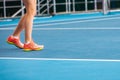 Legs of young girl in a closed tennis court with ball and racket Royalty Free Stock Photo