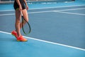 Legs of young girl in a closed tennis court with ball and racket Royalty Free Stock Photo