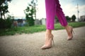 legs of a young girl in heels in step on grass background