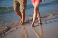 Legs of a young man and woman walking along near the sea Royalty Free Stock Photo