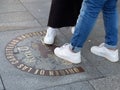 Legs of young people step on zero kilometre sign in Puerta del Sol square in Madrid, Spain Royalty Free Stock Photo