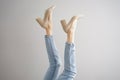 Legs of a young woman in jeans and shoes on a gray background Royalty Free Stock Photo