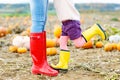 Legs of young woman and little girl daugher in rainboots, red and yellow