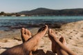 Legs of a young woman and man lying on the beach on sunny summer day. Royalty Free Stock Photo