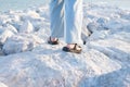 Legs of a young woman on pile of rocks to block the waves of the sea Royalty Free Stock Photo