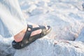 Legs of a young woman on pile of rocks to block the waves of the sea Royalty Free Stock Photo