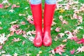 Legs of young woman in red rainboots.