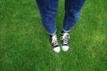 Legs of young woman standing on green grass in park Royalty Free Stock Photo