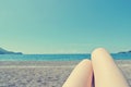 Legs of a young woman sunbathing on the beach, retro/vintage