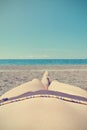 Legs of a young woman sunbathing on the beach, retro/vintage