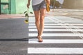 Woman crossing the street at a crosswalk, summer in city