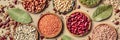 Legumes assortment, overhead panorama on a brown rustic background. Lentils, soybeans, chickpeas, red kidney beans