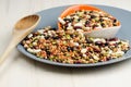 Legumes in a dish on wood, with spoon, close up