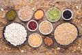 Legumes, lentils, chickpeas and beans assortment in various bowls on wooden background, top view