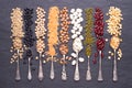 Legumes, lentils, chikpea, dry peas and beans in spoons on stone background. Top view Royalty Free Stock Photo