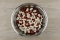 Legumes - a source of protein and micronutrients: red and white beans in a metal plate on the table, in the center; a vegetarian