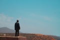 Legzira, Morocco - unrecognizable adult man stands contemplatively on the edge of a cliff with head down. Royalty Free Stock Photo