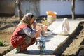 Leh, India - April 15, 2016 : Unidentified old Ladakhi woman in traditional dress and hat drinking tea