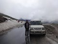 a cab on highway road passing through the hills and snow covered peaks in Leh, India