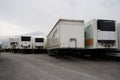 Several white semi-trailer or trailer without a front axle from different transport companies.