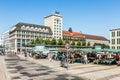 people enjoy shopping at the outdoor farmers market at the market square in Leipzig with old town hall in background