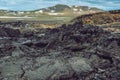 Leirhnjukur old black lava field, green mountains with snow and blue sky in Iceland, overcast day in summer , film effect with Royalty Free Stock Photo