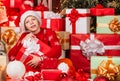 Leisure and activity. Boxing day. Intrigued cute santa. Child little happy boy find gifts near christmas tree. Gifts Royalty Free Stock Photo