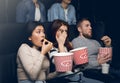 Young people scared of horror movie in film theater Royalty Free Stock Photo
