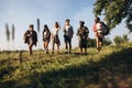 Group of friends, young men and women walking, strolling together during picnic in summer forest, meadow. Lifestyle Royalty Free Stock Photo