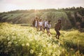 Group of friends, young men and women walking, strolling together during picnic in summer forest, meadow. Lifestyle Royalty Free Stock Photo