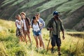 Group of friends, young men and women walking, strolling together during picnic in summer forest, meadow. Lifestyle Royalty Free Stock Photo