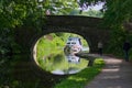 Leisure boat passing under stone built bridge on the canal