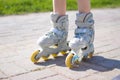 Kids legs in roller skates - leisure, childhood, outdoor games and sport concept